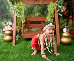 pre-birthday-photoshoot-delhi-krishna-theme-red-dhoti-peacock-crown-pearl-crawling-81